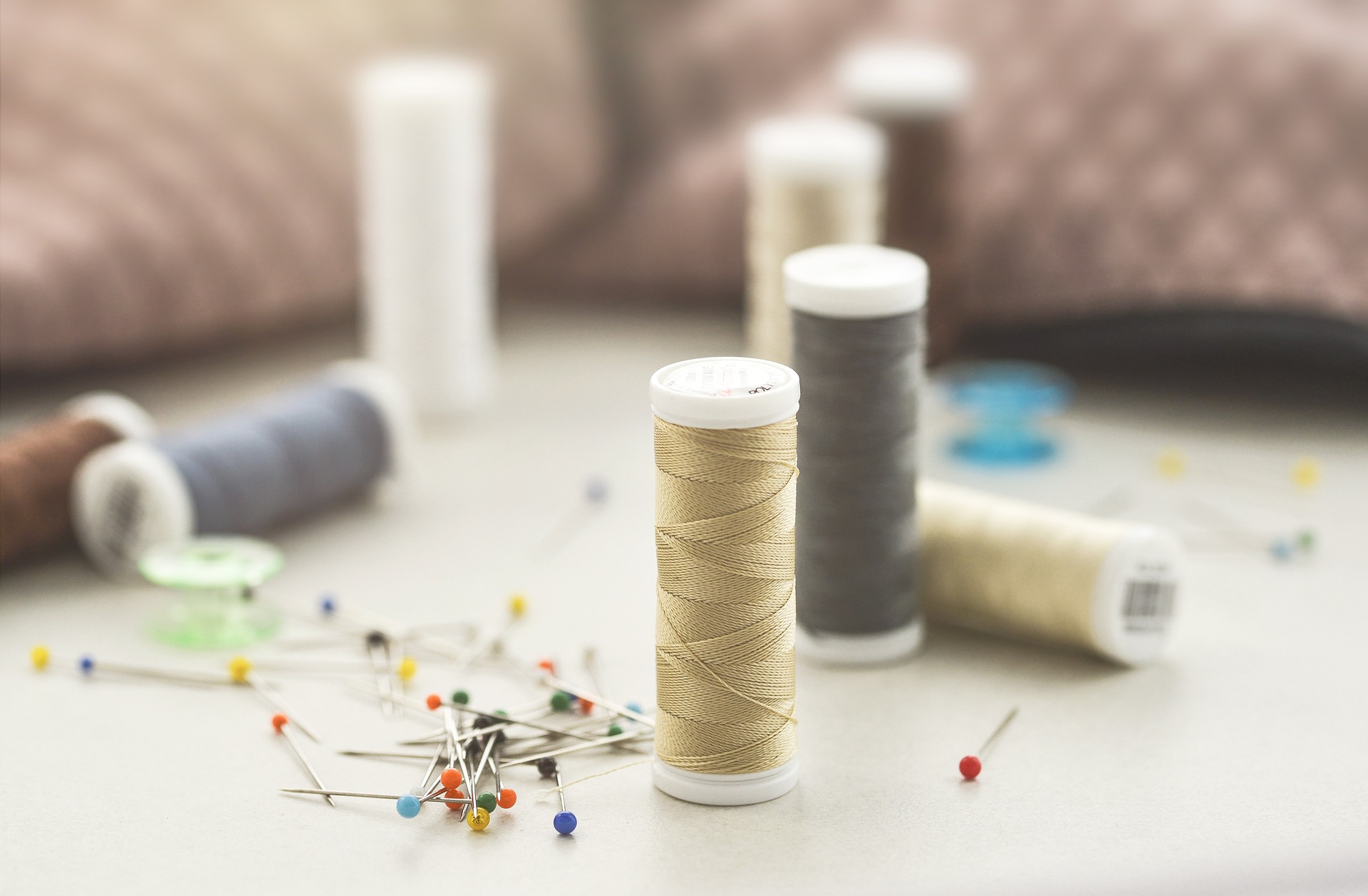 Collection of thread spools and sewing pins
